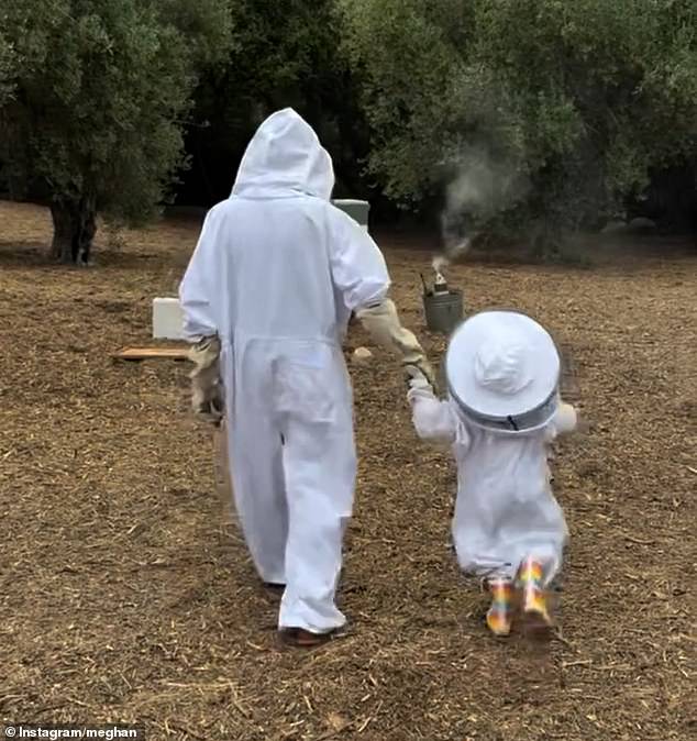 Meghan and Lilibet walking towards the beehive