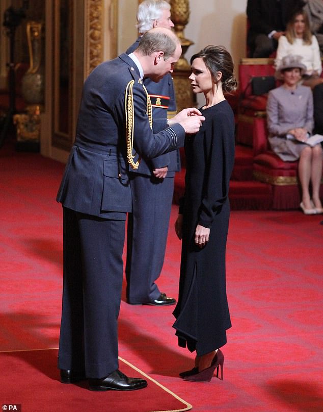 Victoria Beckham receives an OBE from Prince William in April 2017