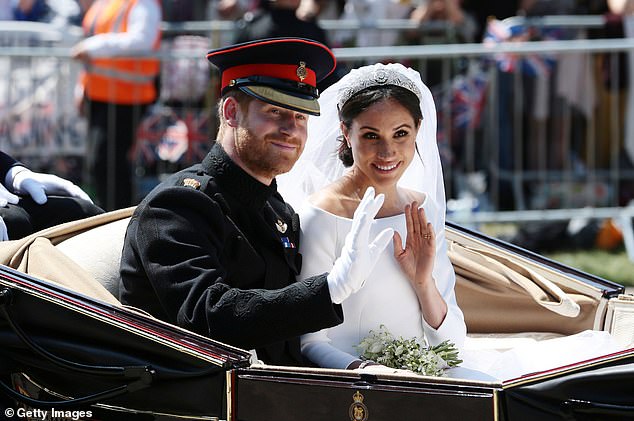 Harry and Meghan wave from the Ascot Landau Carriage during their carriage procession on Castle Hill outside Windsor Castle in Windsor, on May 19, 2018 after their wedding ceremony