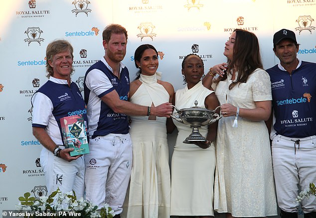Ms James said the crowded stage made the 'pose set-up very awkward', pointed out that Meghan was already in an awkward spot behind the cup when Dr Sophie Chandauka (centre) stepped on stage