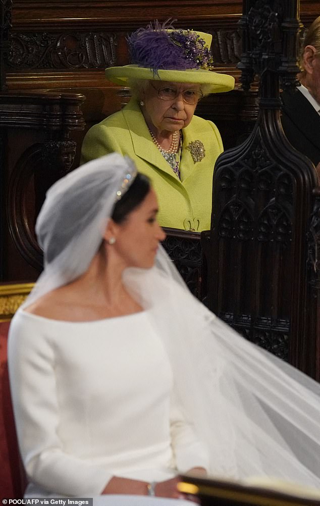 The Queen looks towards Meghan on the Duchess's wedding day. The late Queen reportedly thought her dress was 'too white' for a divorcee