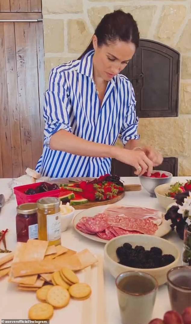 In the clip, Meghan introduced her board as 'easy entertaining,' and decorated a wooden board with various fruits, cheeses, and crackers, as well as her sold-out, $14 As Ever raspberry spread