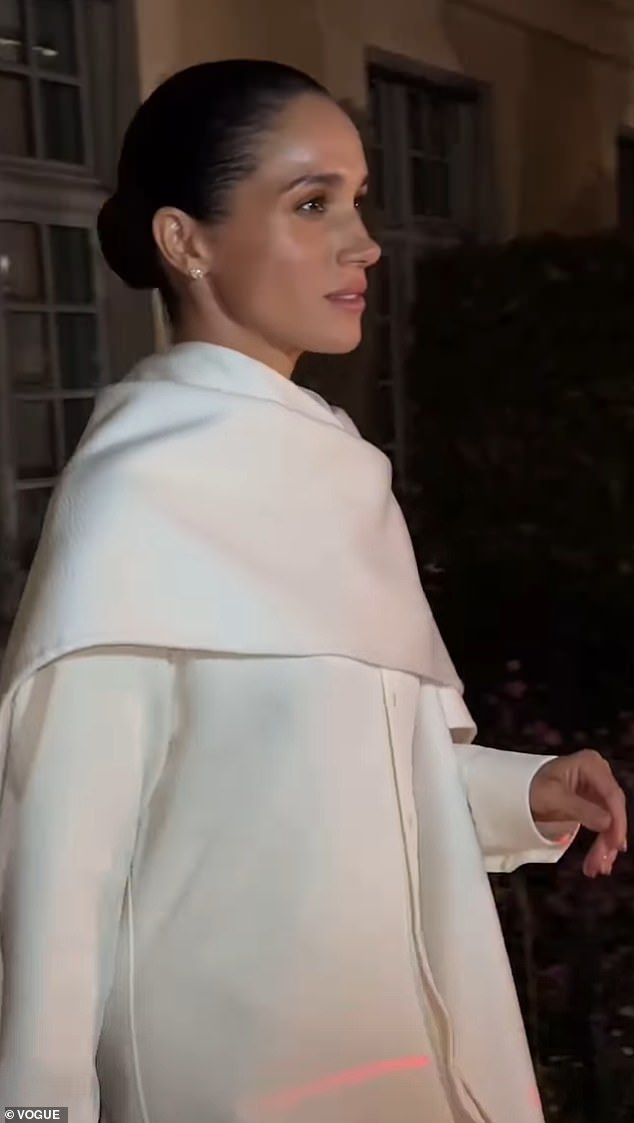 Meghan walks in her full-white outfit and black heels at Paris Fashion Week