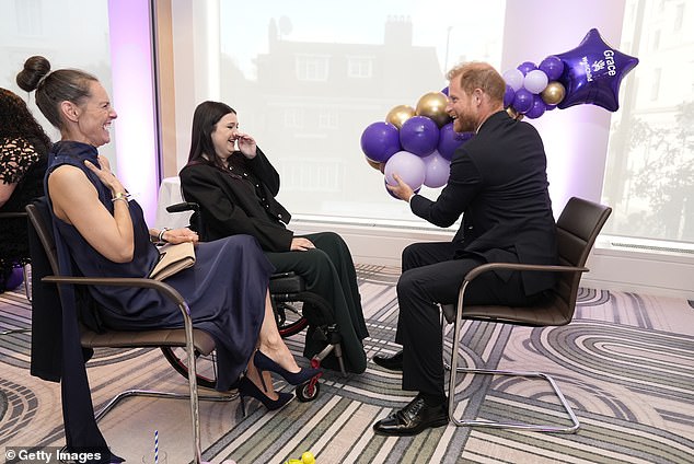 Prince Harry, Duke of Sussex, laughs with 13-year-old Grace Tutt (centre), recipient of the Special Recognitions award at the WellChild Awards