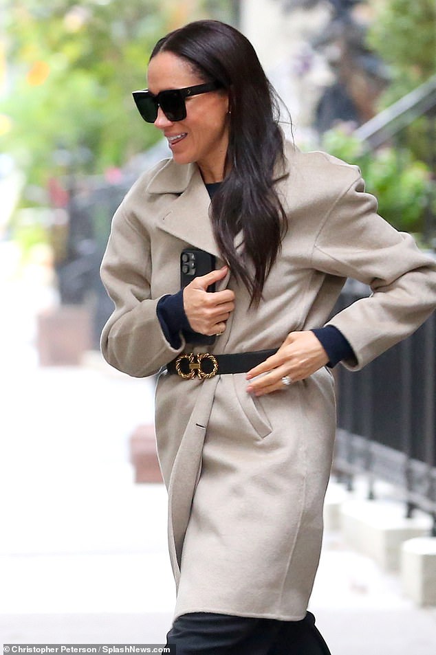 The Duchess of Sussex Meghan Markle steps out in a beige coat and black trousers on a rainy day in New York City after visiting Gloria Steinem
