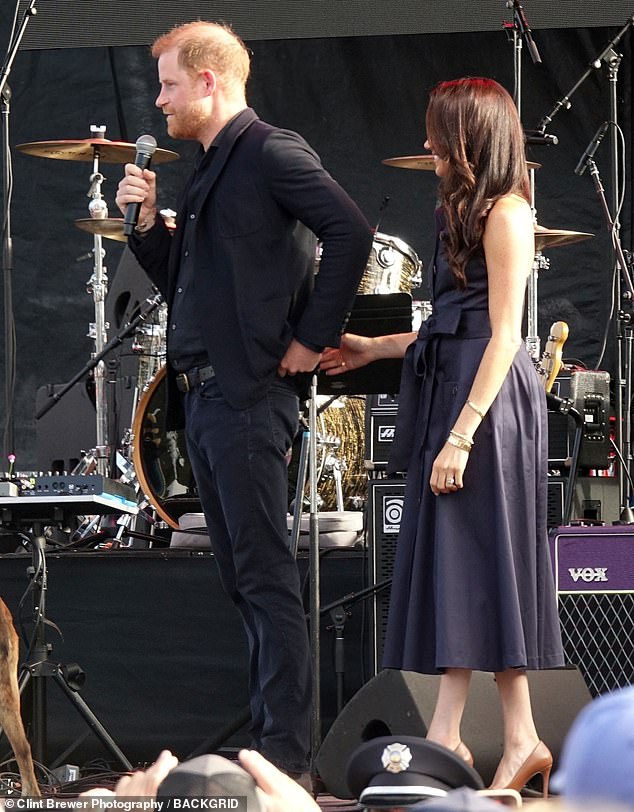 Meghan and Harry then took to the stage to address the crowd and cozied up together as the Duke of Sussex said a few words