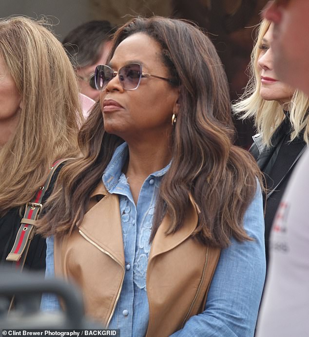 Oprah accessorized the outfit with a pair of flashy gold earrings as well as a stylish sunglasses