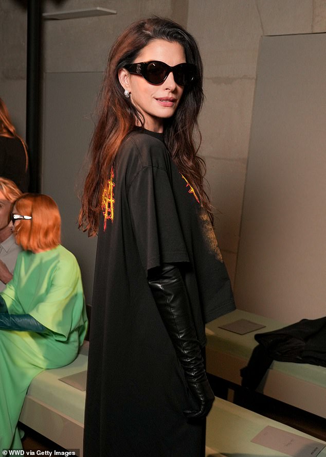 Anne wore a black printed top that cut off at the waist but trailed at the back, with wide leg flowing trousers, completing her look with PVC elbow-length gloves