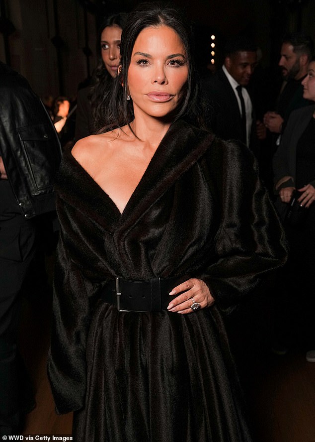 Jeff Bazo's wife Lauren Sánchez rocked a luxurious dark brown coat that draped off one shoulder and featured a plunging neckline