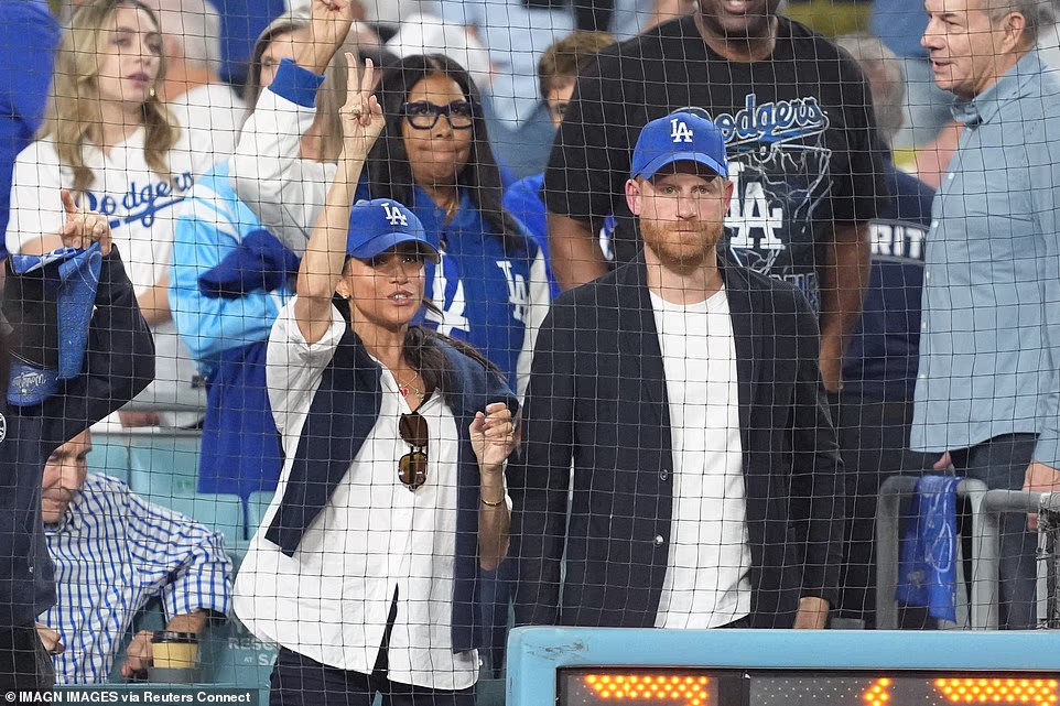 Prior to the game, MLB posted a clip of a smiling Harry and Meghan greeting fans as they made their way into the stadium, flanked by security on the way to their seats. Meghan sat on Harry's right in the front row of the crowd, in a highly sought-after seat directly behind the pitch clock. It is unclear whether they paid for the seats, or were invited as VIPs by the team. Both wore blue Dodgers caps, and the superstar pair were matching with the rest of their outfits too, pairing white shirts with a blue over-layer. Their decision to rep LA over Toronto also left some fans perplexed, given both of their connections to Canada.