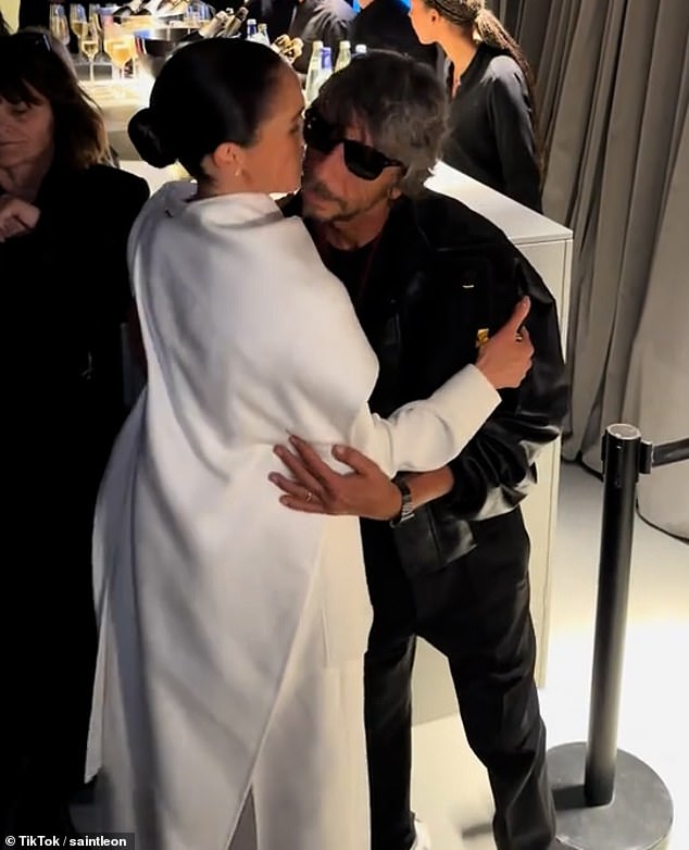 Meghan Markle shares an awkward kiss with Italian fashion designer Pierpaolo Piccioli as she made a surprise appearance at Paris Fashion Week that he helped make happen for her
