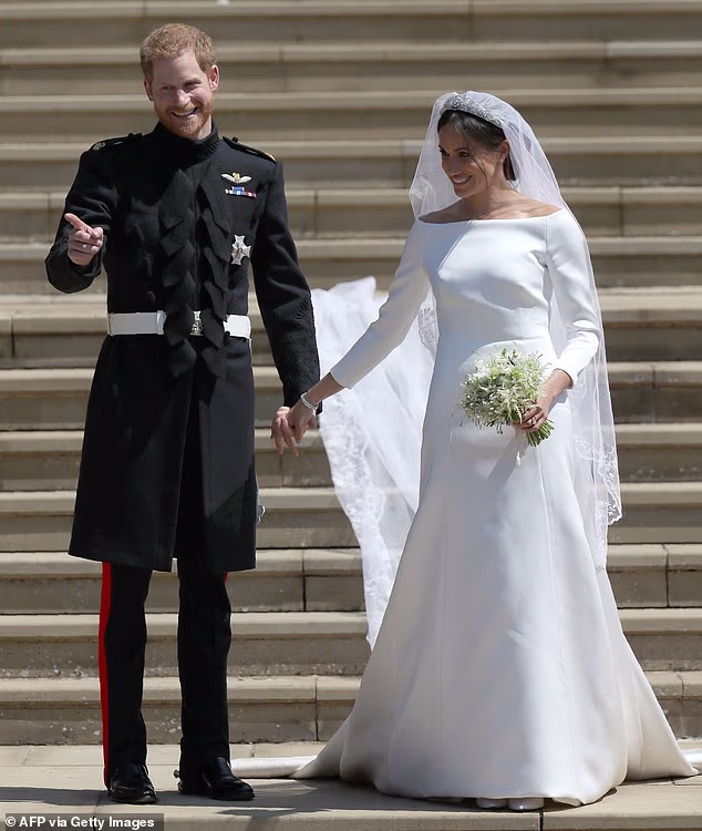 The Duke and Duchess of Sussex walk down the west steps of St George's Chapel, Windsor Castle, in Windsor, on May 19, 2018 after their wedding ceremony