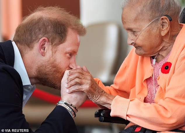 Prince Harry kissing the hand of Villa Shah, 91, during a visit to Sunnybrook Hospital's veterans centre in Toronto