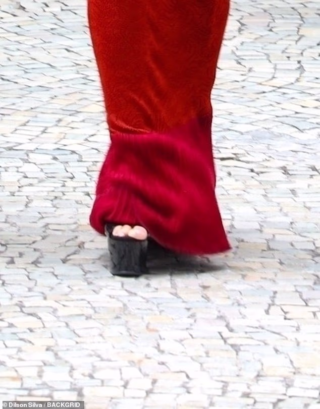 The reality TV star was pictured clinging to her security guard for support as she tried to keep steady while walking in black platform heels