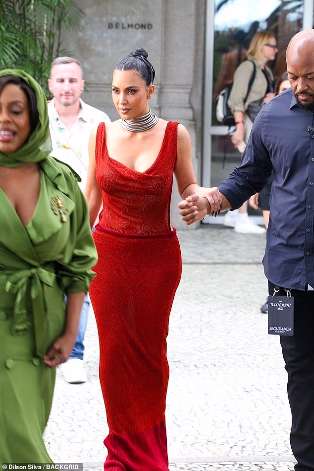 Kim sizzled in a plunging red dress that highlighted her famous hourglass curves, with the floor-length design making it even trickier for her to walk