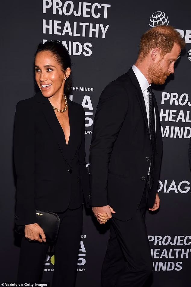 Meghan smiled at someone as Harry edged away