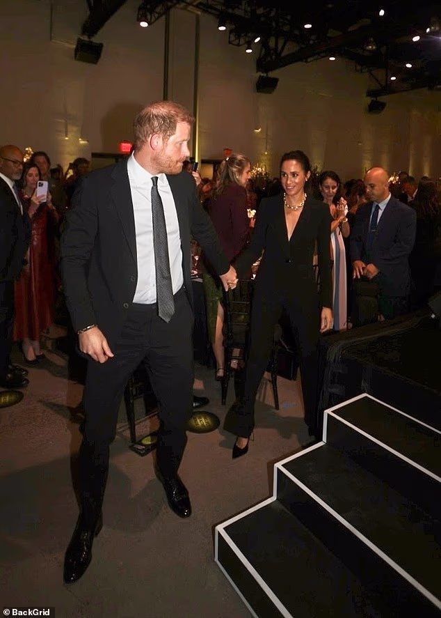 Harry and Meghan are clapped as they go on to stage