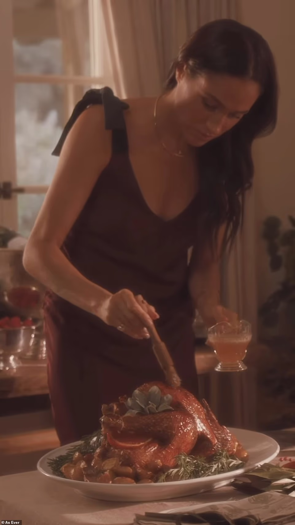 'Our table is set with a seat just for you,' the caption of the post read. But instead of the decor, it was Meghan's expensive outfit that made headlines. She donned a Marion burgundy slip dress from Heidi Merrick, a brand local to Santa Barbara, which is a stone's throw away from Meghan and Prince Harry 's $14 million Montecito mansion. The gown, which she bought in a rich burgundy color, featured an elegant v-neck and black straps that tied into a bow.