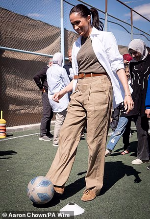 Pictured: The Duchess of Sussex dribbles with a football during a visit to the QuestScope Youth Center at the Za'atari refugee camp, home to displaced Syrians, near Mafraq in northern Jordan