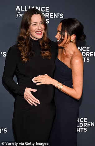 Meghan was invited to cradle her bump