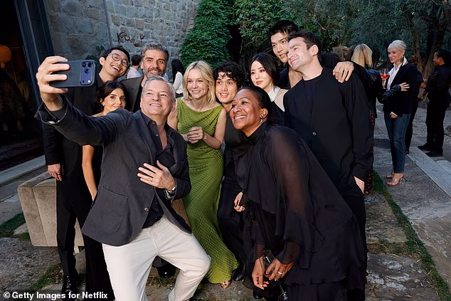 Ted Sarandos taking a selfie with the stars of Beef and other guests, most of whom appear to have stuck to a monochrome dress code