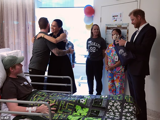 Prince Harry and Meghan Markle, the Duke and Duchess of Sussex, meet patient Hamish and family members on the Adolescent Oncology and Rehabilitation ward