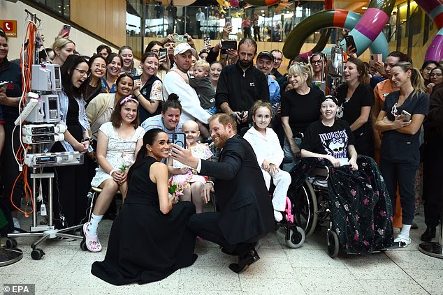 Harry and Meghan pose for a selfie with patients at the Royal Children's Hospital in Melbourne on the first day of their visit