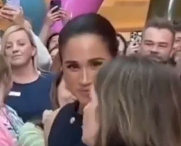 Meghan closes in on Ms Fosmo and her smile tightens as the couple's chief-of-staff seems just intent on getting the prince to notice the enthusiastic crowd above them
