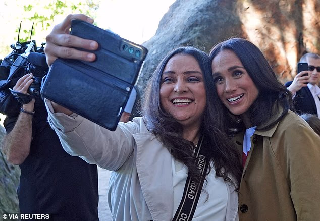 When asked whether the trip improved their opinion of the pair, just 19 per cent said yes, while a striking 81 per cent said it had not. (Meghan pictured posing for a selfie with a fan at the Scar Tree Walk in Melbourne on April 16)