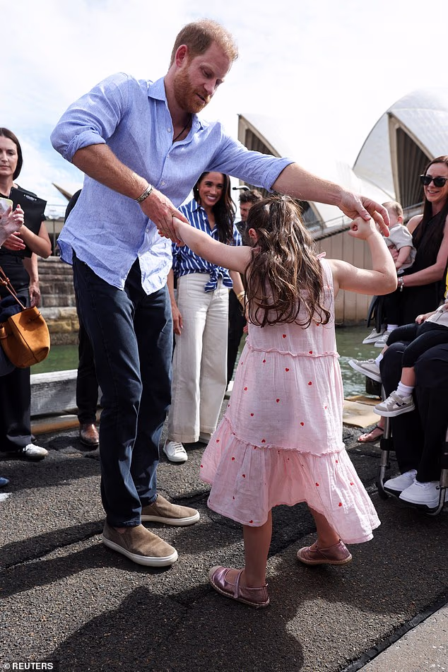Prince Harry sweetly 'twirled' a young royal fan around during an event in Sydney today as the Sussexes concluded their tour of Australia