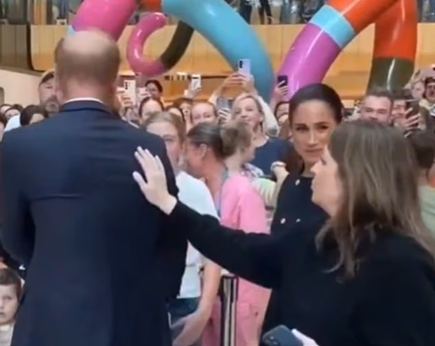 Sussex staff Sarah Fosmo pats Harry on the back during the couple's inaugural event of their Australian tour at the Children's Hospital in Melbourne