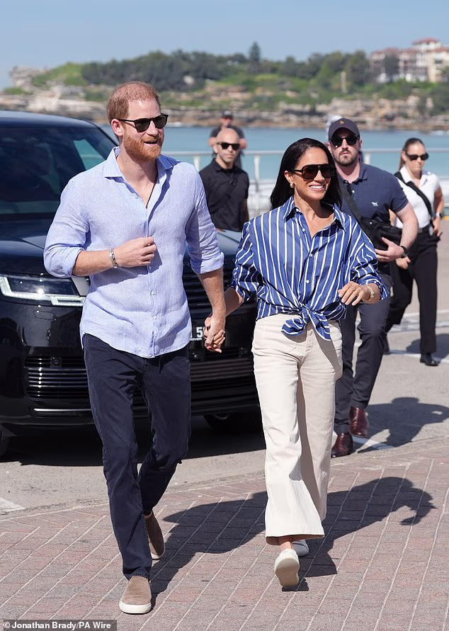 Pictured: Harry and Meghan during their visit to Bondi Beach in Sydney as part of their quasi-royal tour Down Under last month