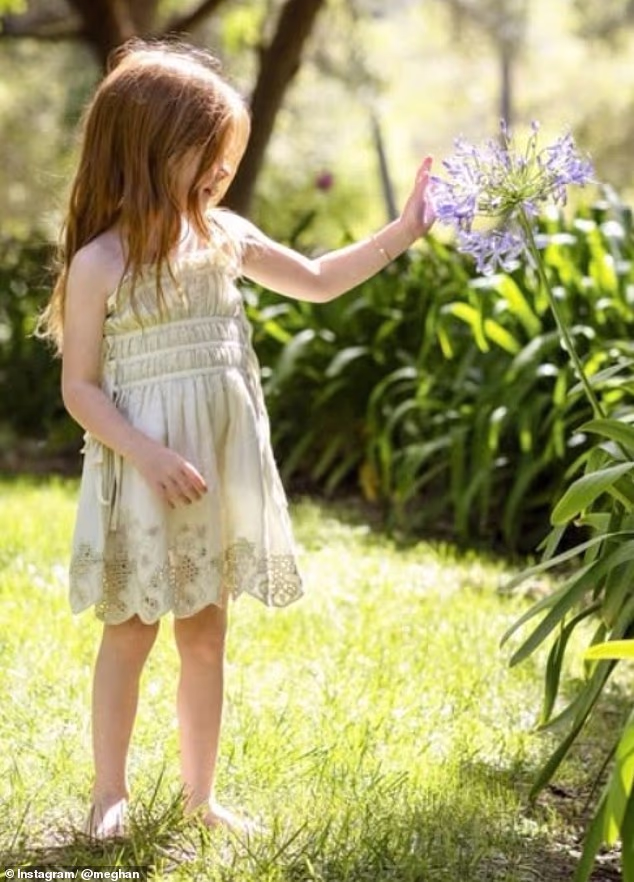 Another photo showed the Sussexes' youngest child standing in the garden of the family's Montecito home as she admired some flowers