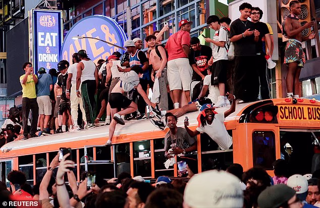 Hordes of fans take over the roof of a New York school bus amid the chaos