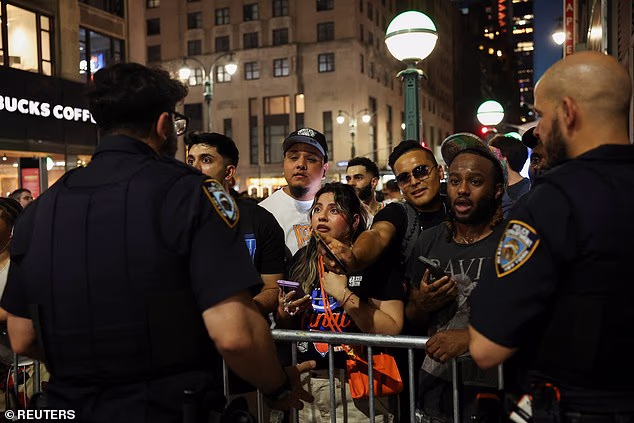 Officers attempt to keep fans at bay as they desperately try to reach the home of the Knicks