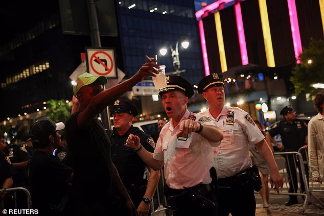 Two NYPD officers are pictured trying to manage the chaos outside of MSG