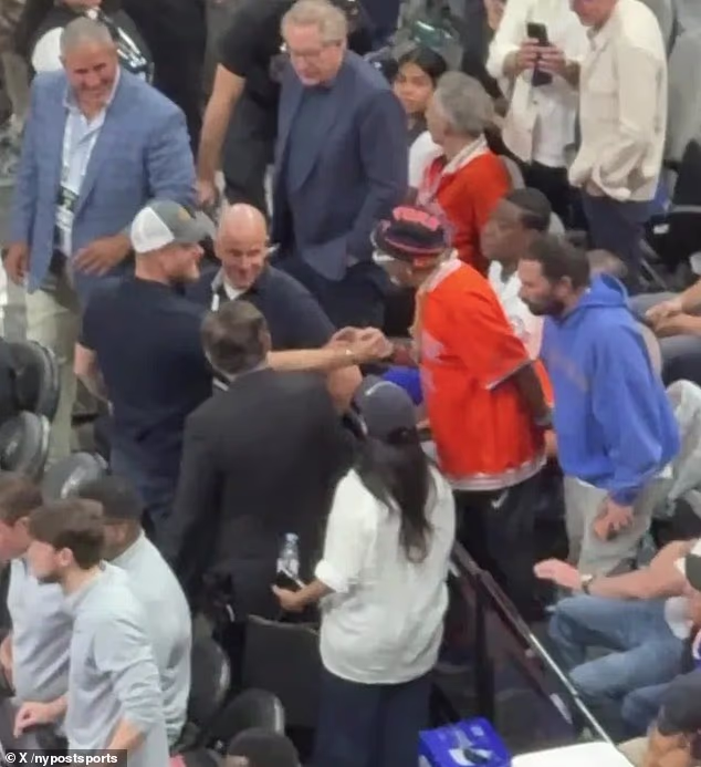 Harry put his hand, awkwardly, on Spike's chest before reaching across and grabbing the director's hand for a swift shake