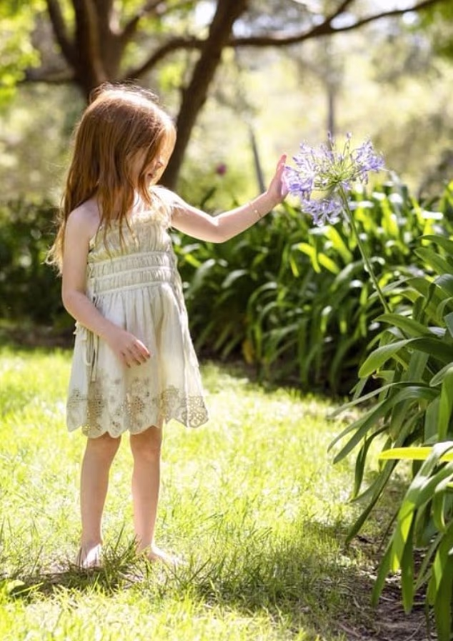 Lilibet’s side profile is shown as she inspected an agapanthus flower in the California sunshine of their Montecito mansion.
