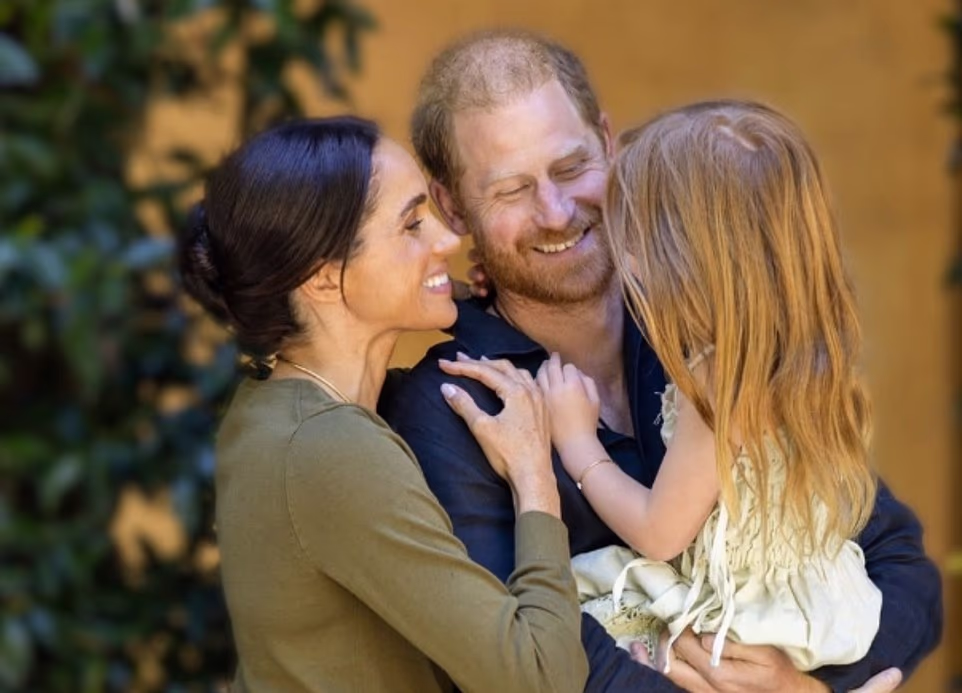 Harry and Meghan have marked their daughter Princess Lilibet's fifth birthday with a new family portrait. The image showing Prince Harry holding Lilibet with her mother smiling adoringly at the five-year old was shared to Meghan's 4.6 million followers on Instagram. Lilibet's strawberry blonde hair, which falls past her shoulders, obscured her face from the camera. Another photo showed the Sussexes' younger child standing in the garden of the family's £11million Montecito home as she admired some flowers. Meghan's caption read: 'Our dream girl. Happy fifth birthday, Lili.' In the photos, Lilibet is wearing a light yellow sundress previously seen in a behind-the-scenes shoot for her mother's lifestyle brand As Ever.