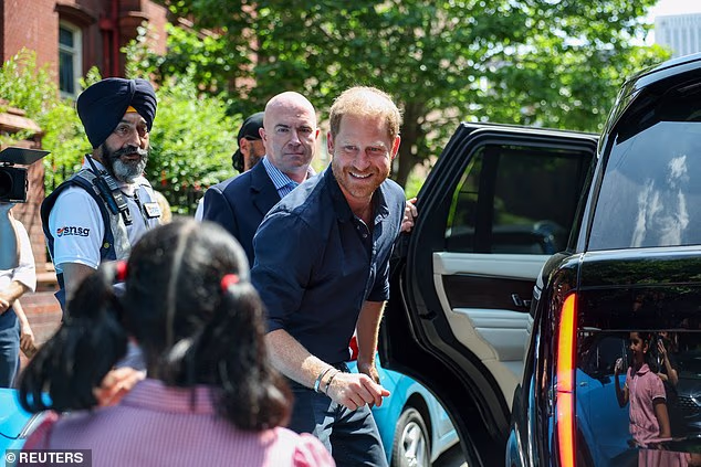 Harry greets a child as he leaves the Birmingham Children's Hospital