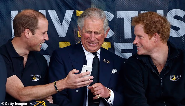 Pictured: William, Charles and Harry looking at an iPhone as they watch the athletics during the Invictus Games at the Lee Valley Athletics Centre in 2014.