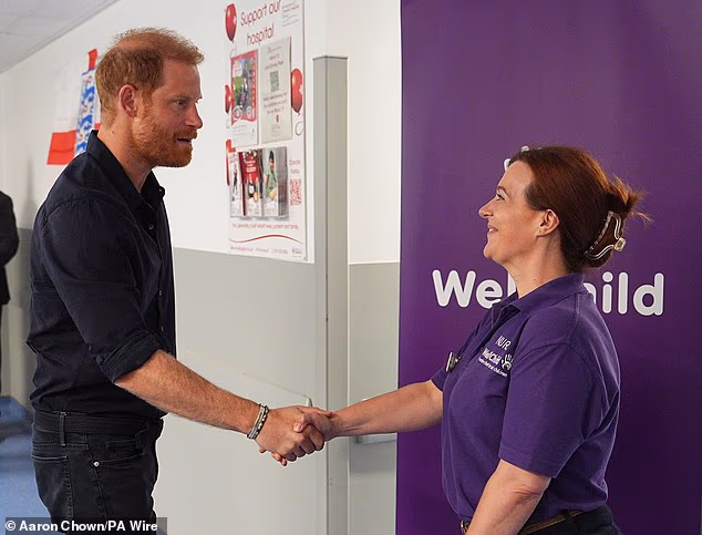 The Duke of Sussex is pictured meeting WellChild nurse Nicky Holt during a visit to the Birmingham Children's Hospital in July