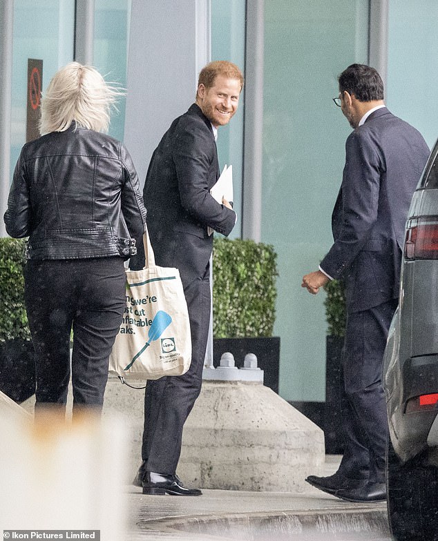 Prince Harry grinned at Heathrow today as he prepared to jet back to California after an awkward appearance at his father's Coronation