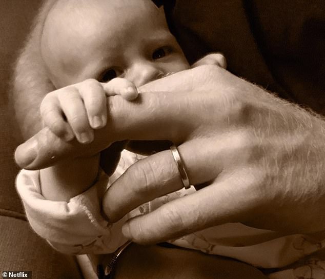 Archie holds his father's hand shortly after his birth. Harry admitted he took several hits of laughing gas to calm his nerves when Meghan gave birth for the first time