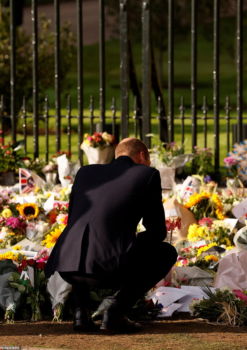 The mourner continued: 'I'm pleased that they came out together and as a family I'm delighted that they all took the time to come and say hello to the crowds. Sad things like funerals bring families together so I hope that when they get back to California they think long and hard about everything that's happened.' Harry only took place after an extended negotiation, which delayed the Sussexes arrival by at least 45 minutes. Pictured: William closely observes tributes left for Queen Elizabeth II on September 10, 2022.