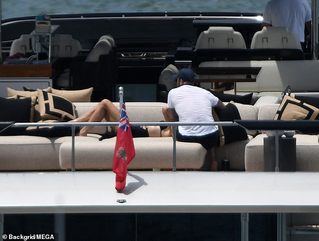 Loved-up: Former Spice Girl Victoria could be seen resting her head on David's legs as she lay next to him