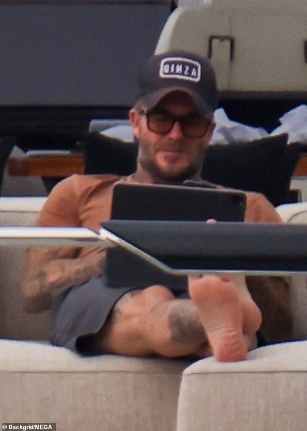 Chilled out: The president and co-owner of Inter Miami CF put his feet up as he sat at the back of the top deck of the boat