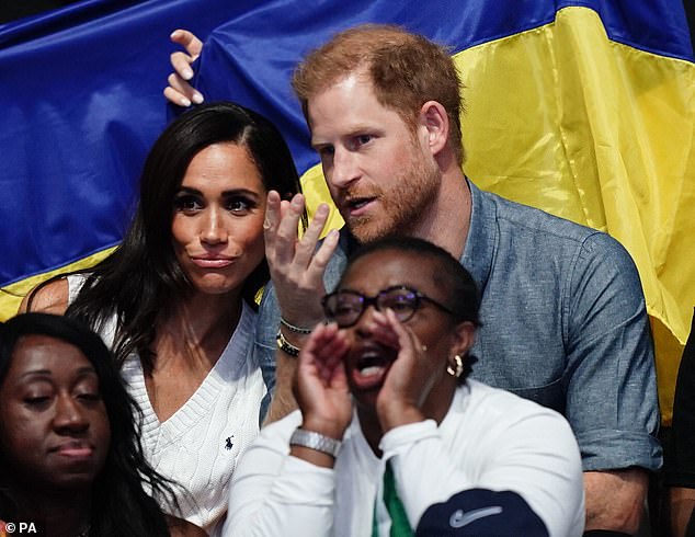 Taking it all in! Meghan and Harry appear deep in concentration as they watch the game