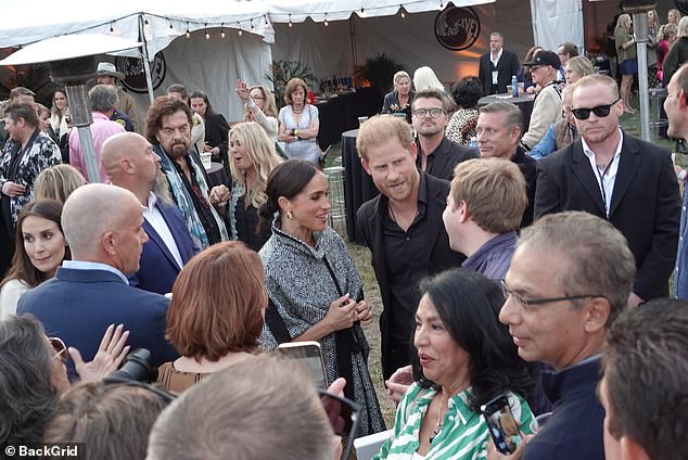 The focus of her outfit was a statement cape-style jacket, which featured a high funnel neck and tie waist, in a black and white striped pattern