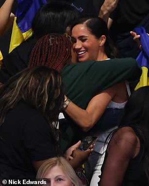 Harry and Meghan share hugs with people in the crowd during today's outing